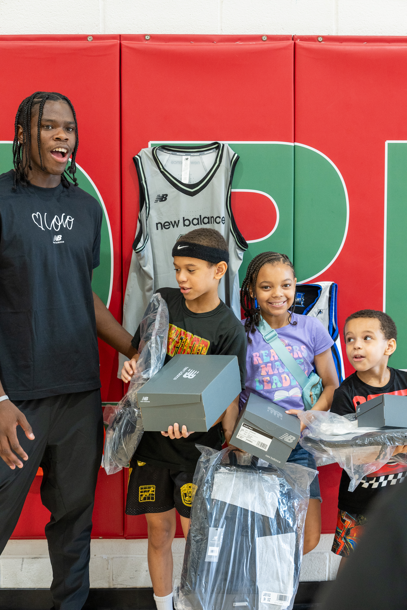 Smith with attendees holding the shoes and shirts they just received.
