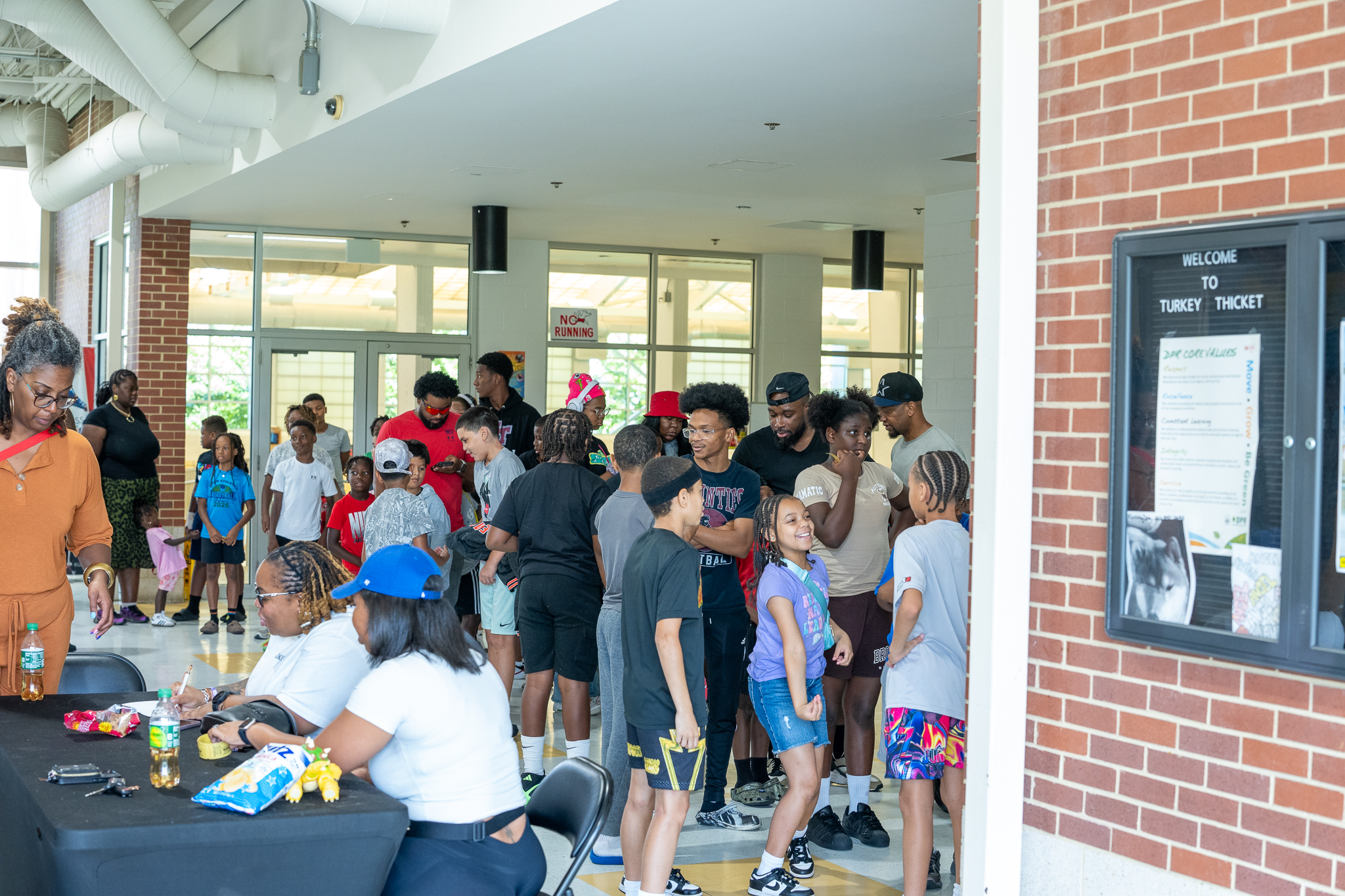Families fill the lobby as the check-in table works through the line before the doors open.