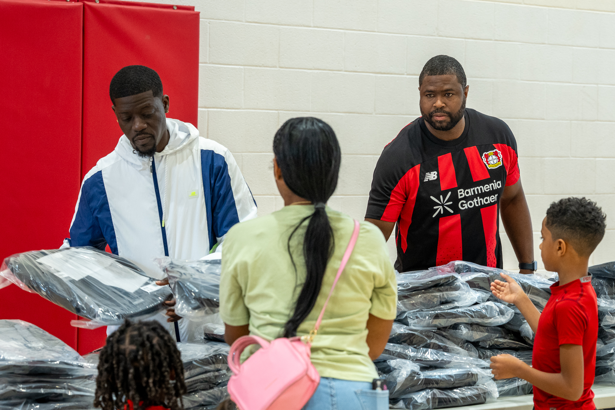 Jordan Smith Sr. works the first table families reached, handing out one of the 100 New Balance backpacks.