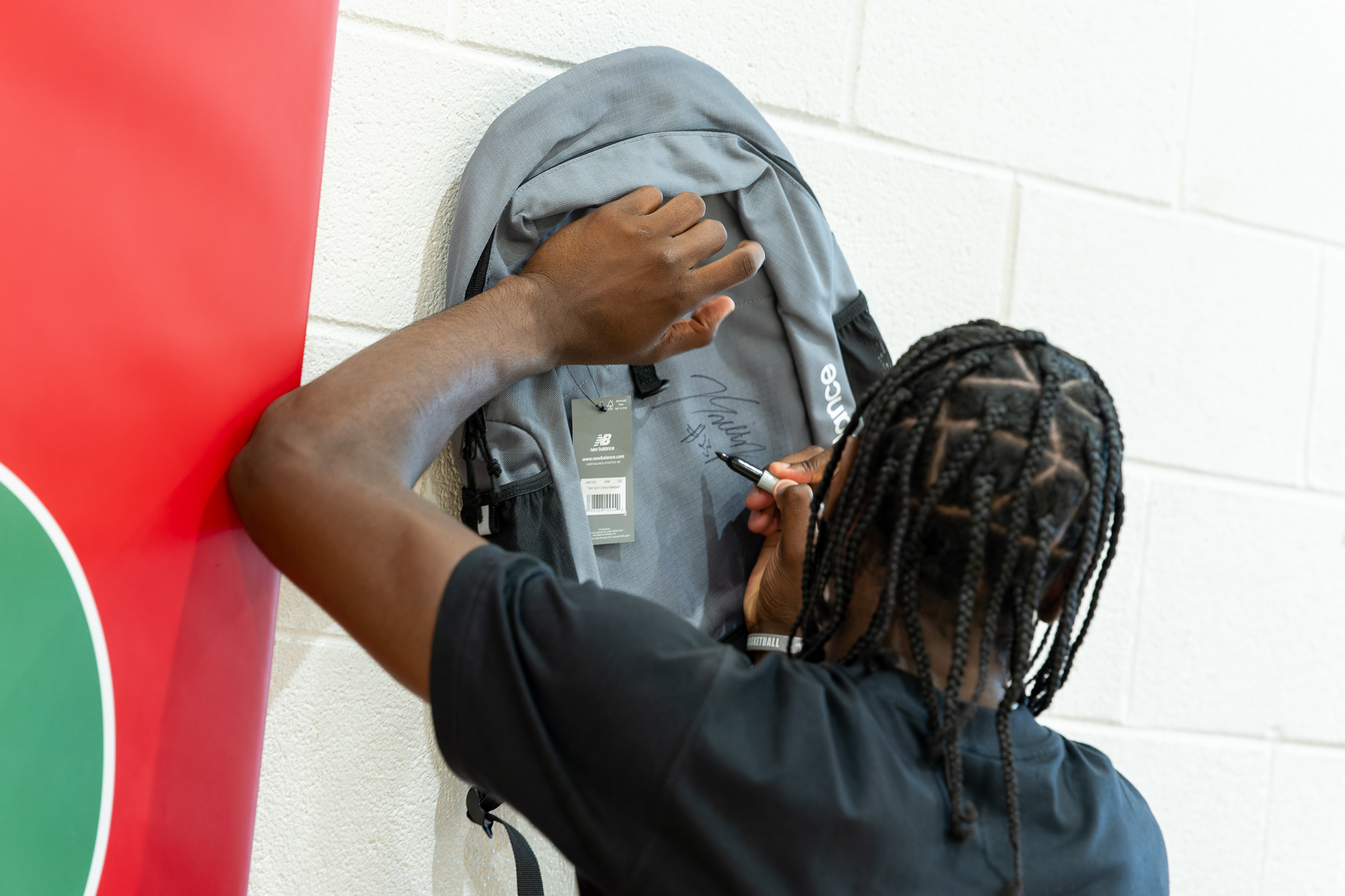 Smith signs a backpack for an attendee.