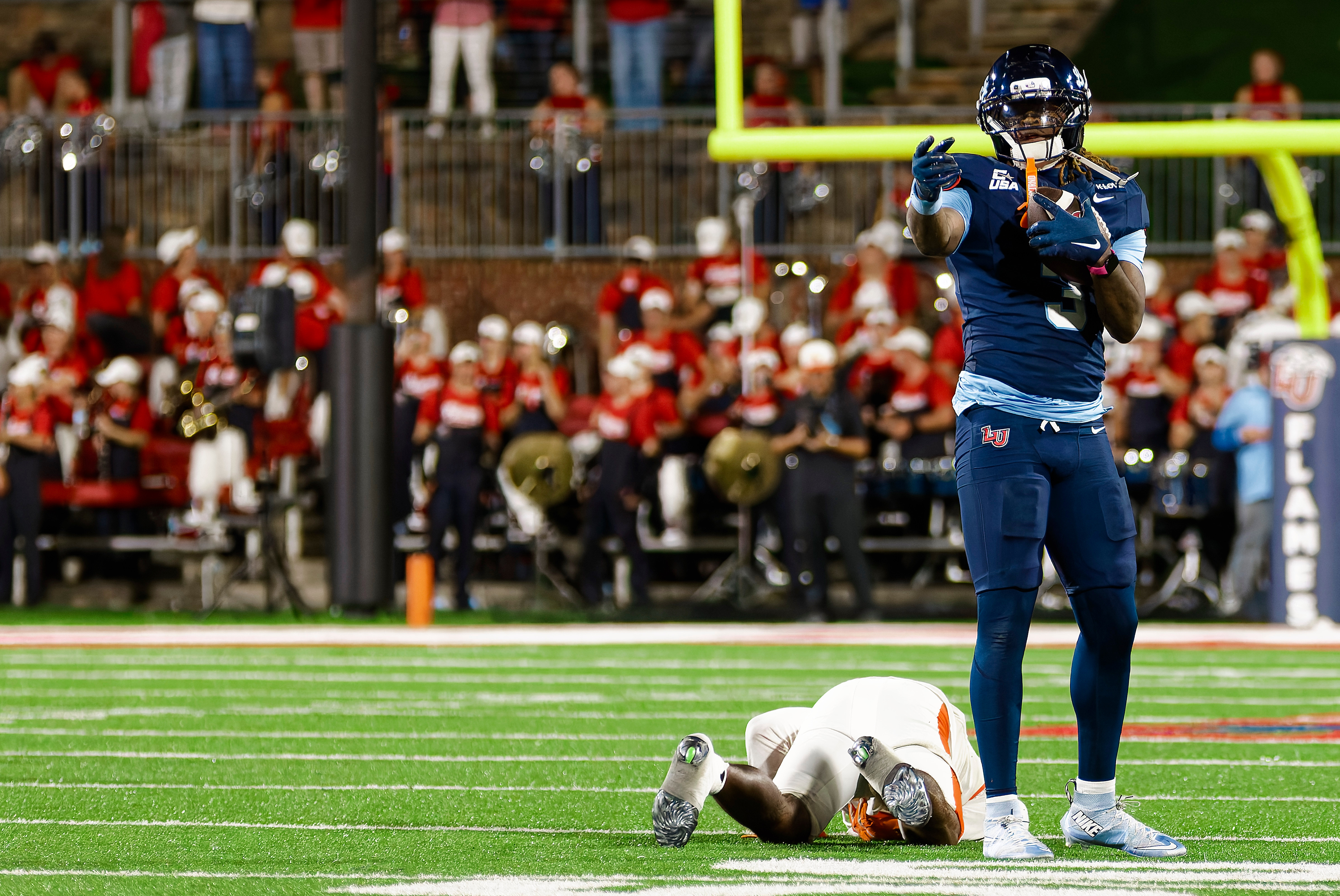 Liberty player holding the ball near the end zone
