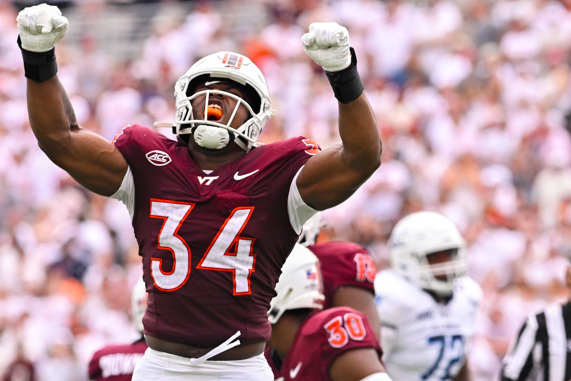 Virginia Tech defender Cortez Harris raises his arms during a game.