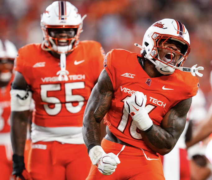 Virginia Tech linebacker Noah Chambers, wearing No. 16 in orange, celebrates during a game.