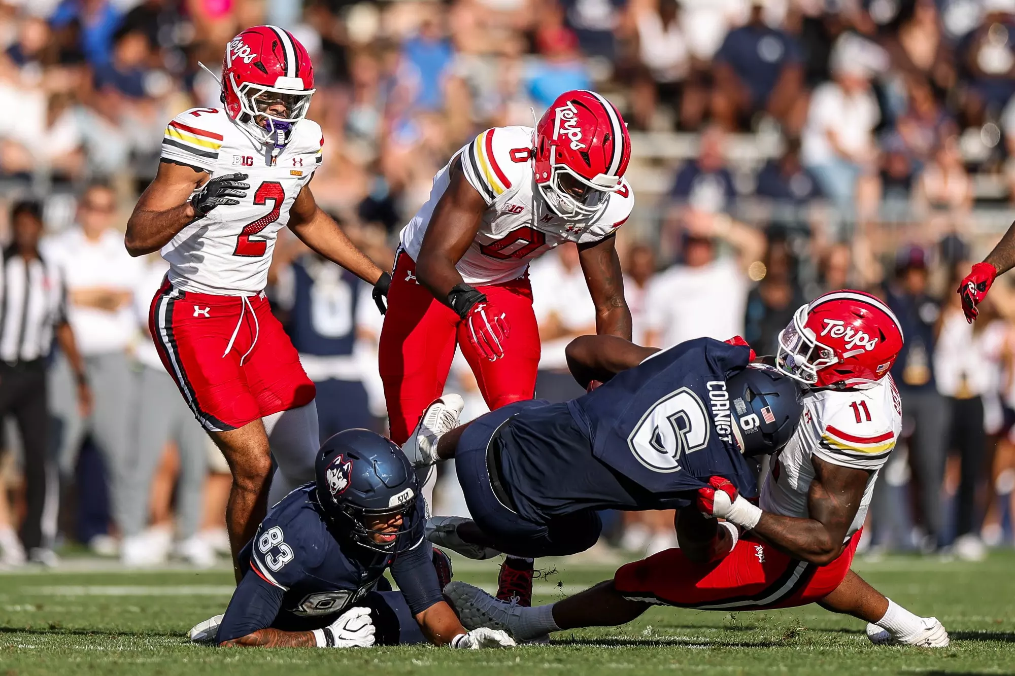 Maryland linebacker Sidney Stewart tackles a UConn ball carrier with Zion Elee nearby. September 12, 2026, East Hartford, Connecticut.