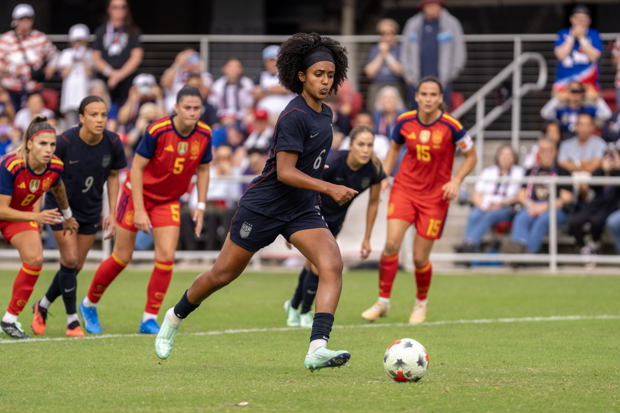 A U.S. player approaches the ball as Spain players watch at Audi Field on October 10.
